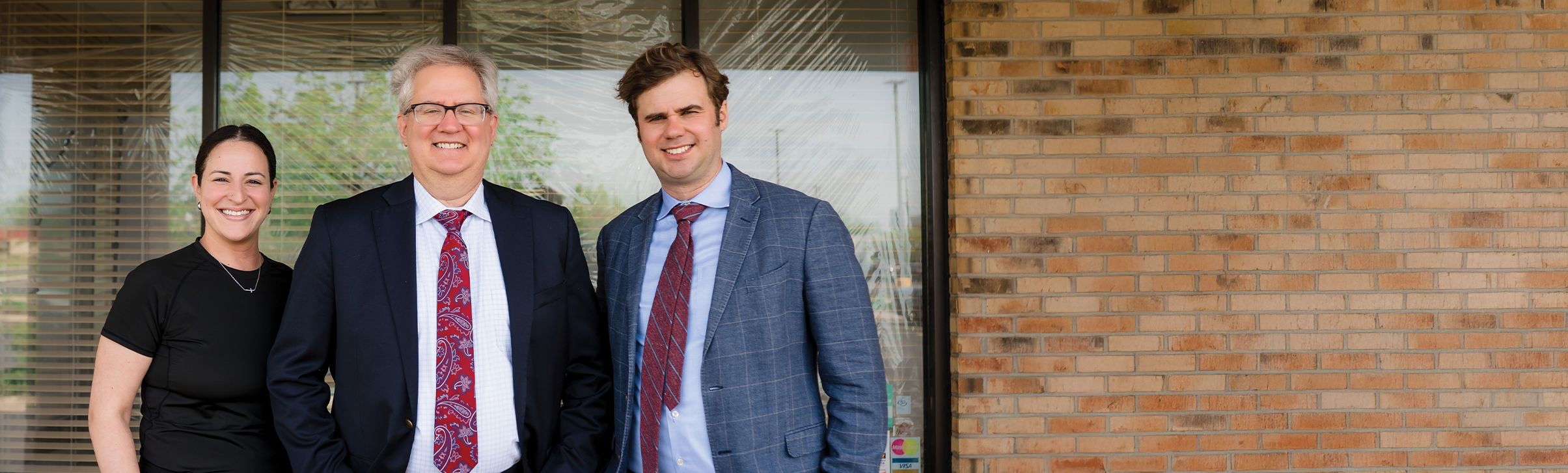 Dr. Gregory Lane, a Dentist in Carol Stream, standing in front of the dental practice's office building, smiling at the camera